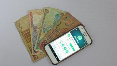 white Android smartphone beside banknotes