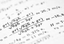 Mathematical formulas are written on a white sheet of paper.