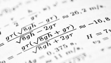 Mathematical formulas are written on a white sheet of paper.