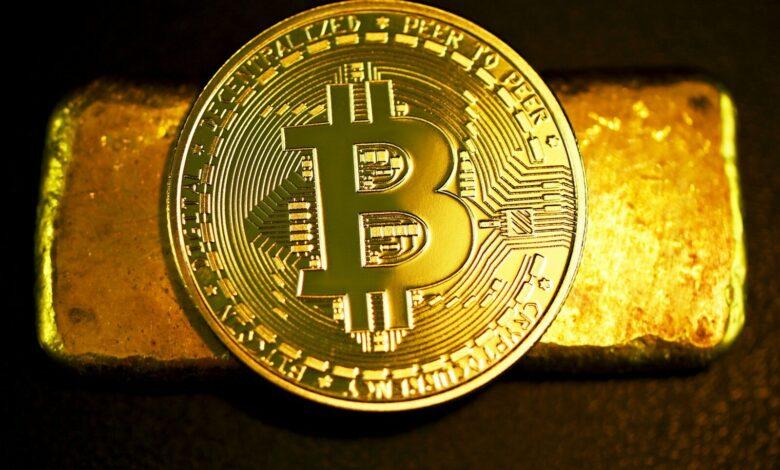 a bitcoin sitting on top of a gold bar